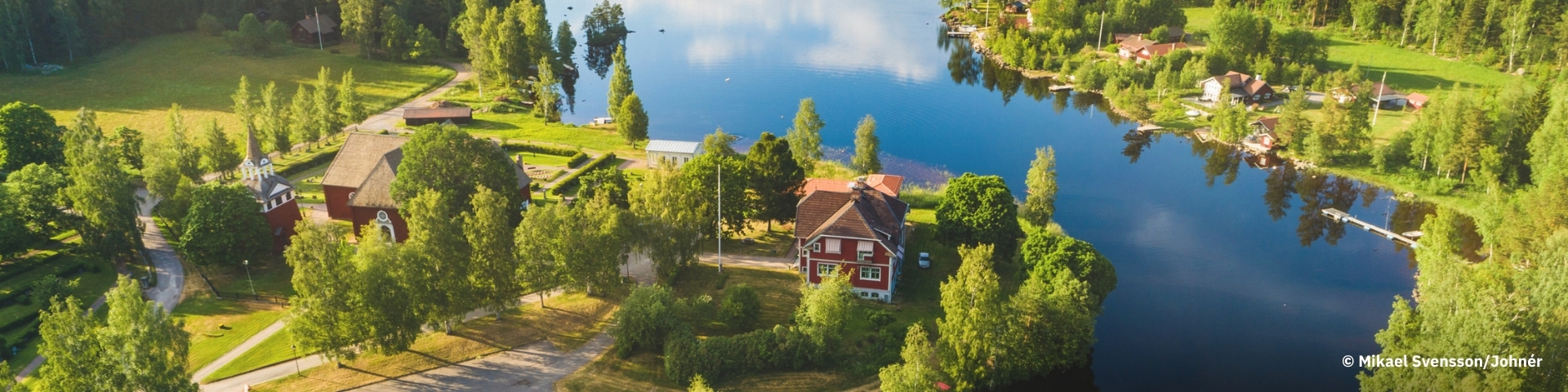 A red house on the bank of a river.