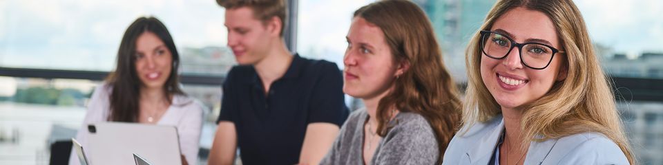 A smiling young woman with glasses.
