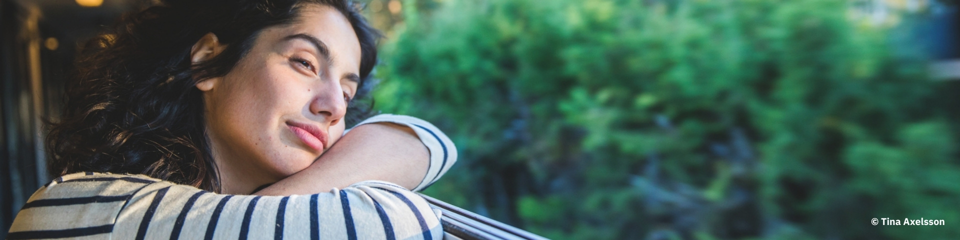 A woman relaxing in a train window.